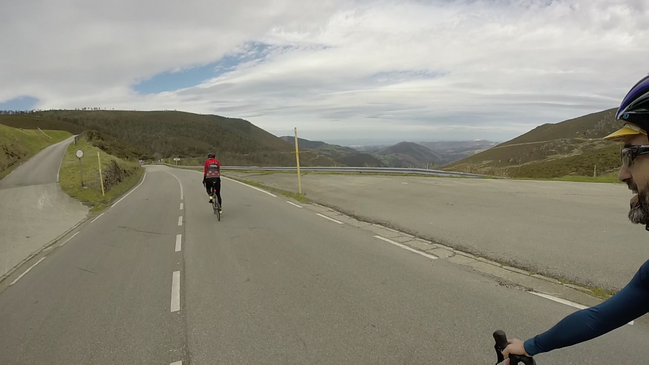 The start of going down a Garganta on the other side. Dani is a bit ahead of me, the road goes straight and on the right side you can see the hills, the valley and a bit far away, the cantabric sea