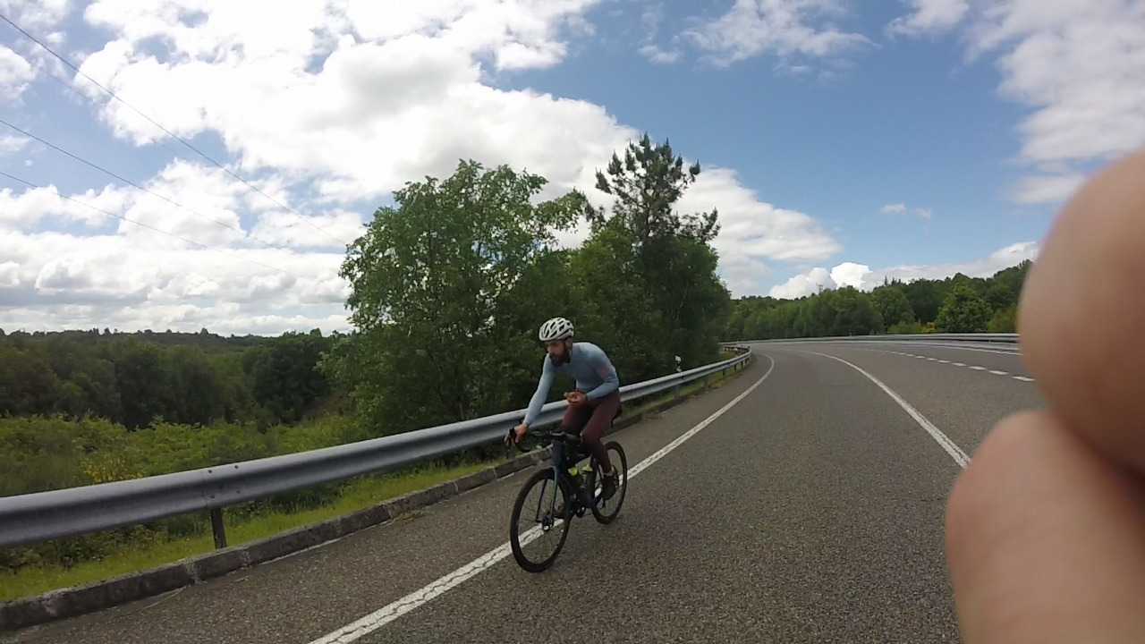 Alex, eating something on the bike while going up another repecho on a big, big road