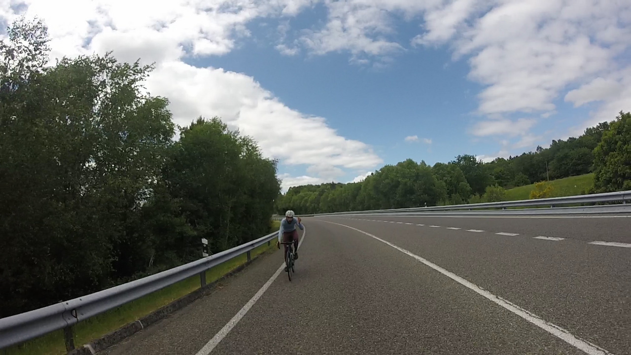 Alex, eating something on the bike while going up another repecho on a big, big road