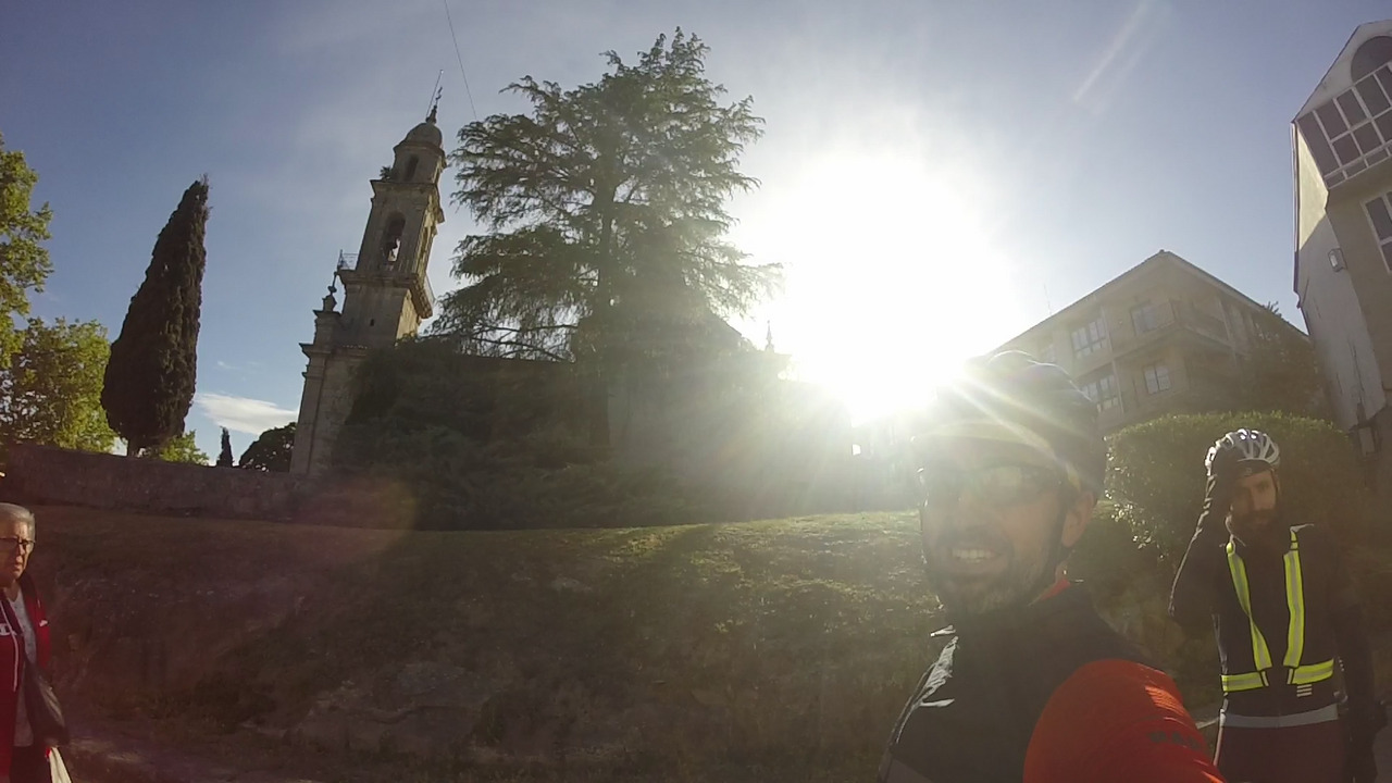 Me, showing a big smile, with the sun shining strong behind my back. Also behind me is the church from the main square in Allariz, the 'Iglesia de Santiago de Allariz'