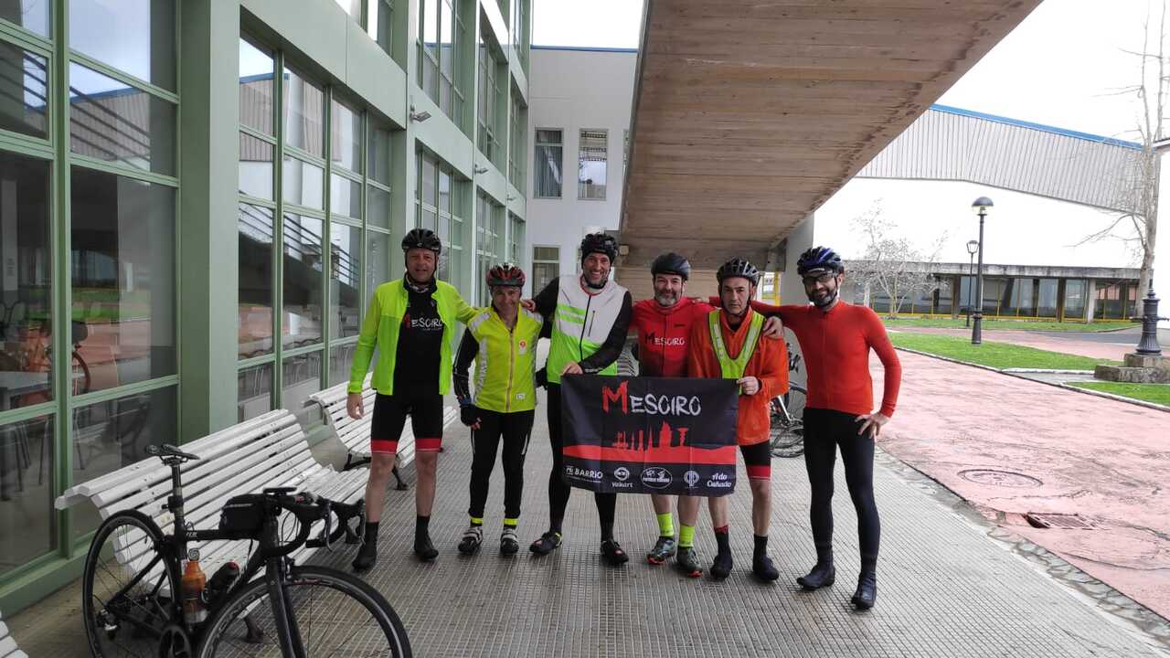 Edgar, me, Jose, Dani and Oscar upon arrival, holding a flag of the Mesoiro cycling club. A bunch of battered, wet, happy and smiling cyclists