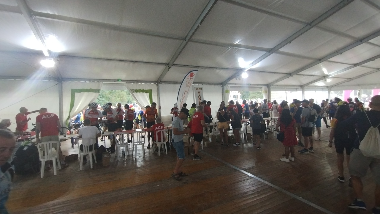 Panorama photo of another of the stamps tables, several randonneurs were getting their stamps from the benèvoles there
