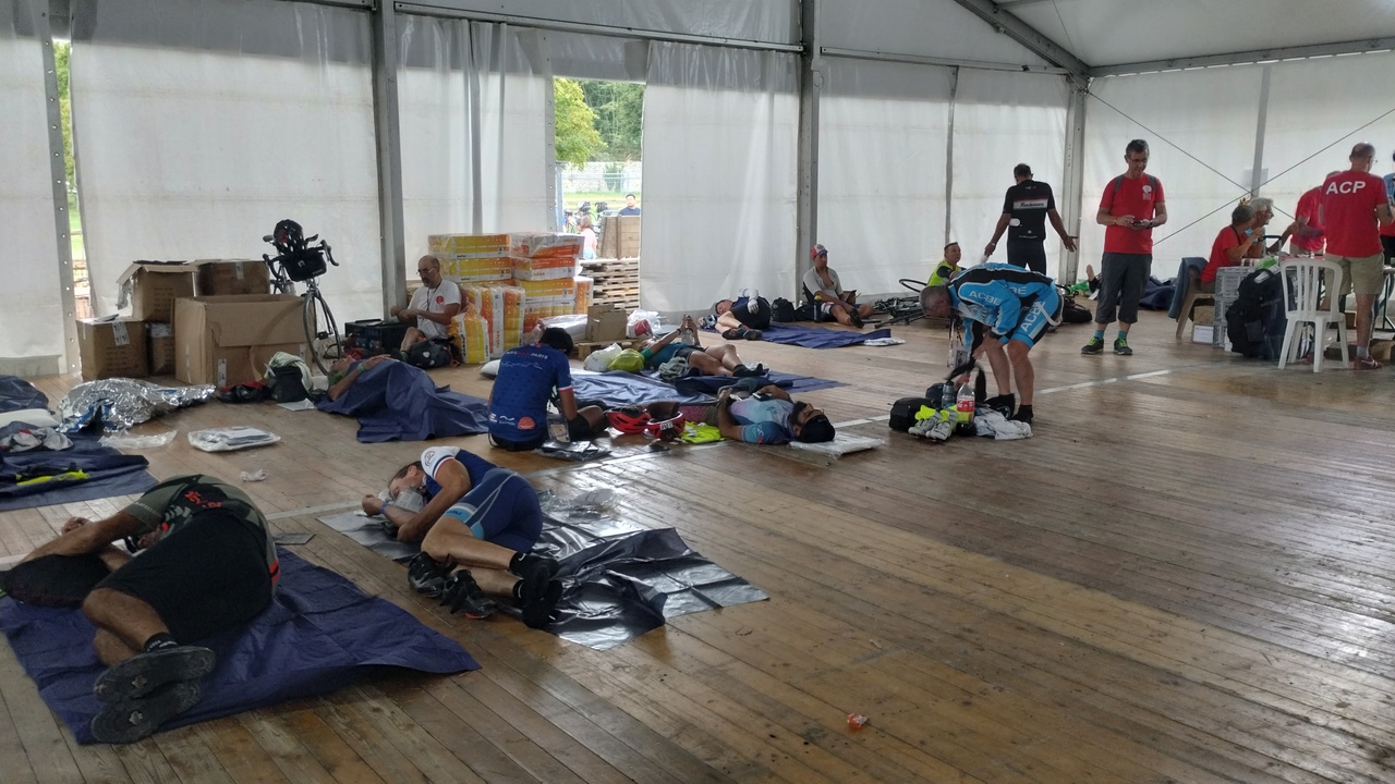 A few randonneurs sleeping on the floor in that same tent, some were waking up, some simply resting a bit