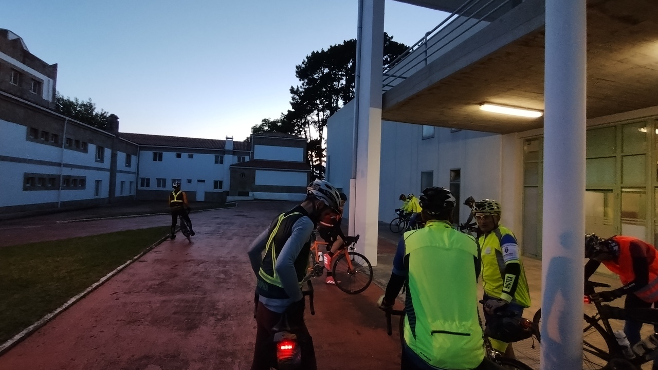 A few randonneurs at the start point before the Brevet, the sun already set and the sky is getting a darker tone of blue