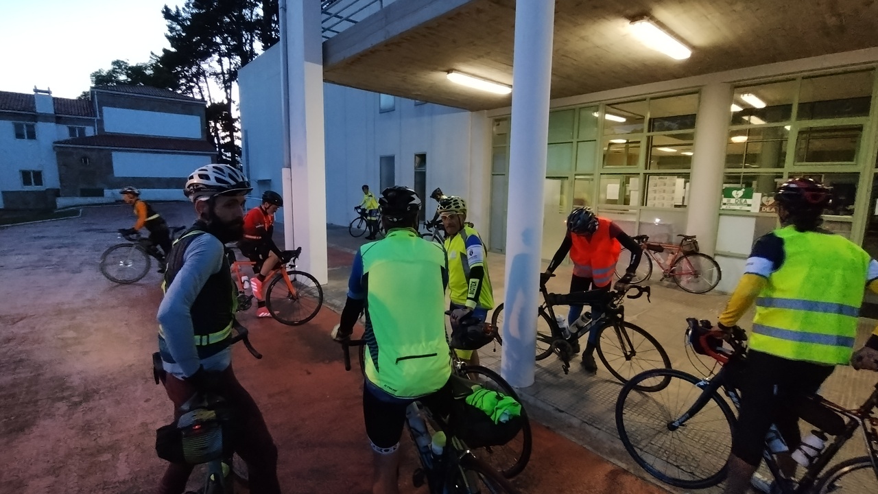 Several randonneurs at the start point in Bastiagueiro, before the start of the Brevet, in the evening, chatting and getting ready