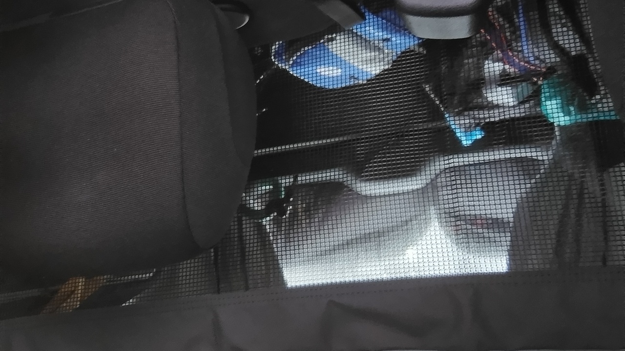 Picture taken from inside the van, backwards, the bikes on the rack being covered with the waterproof cover.