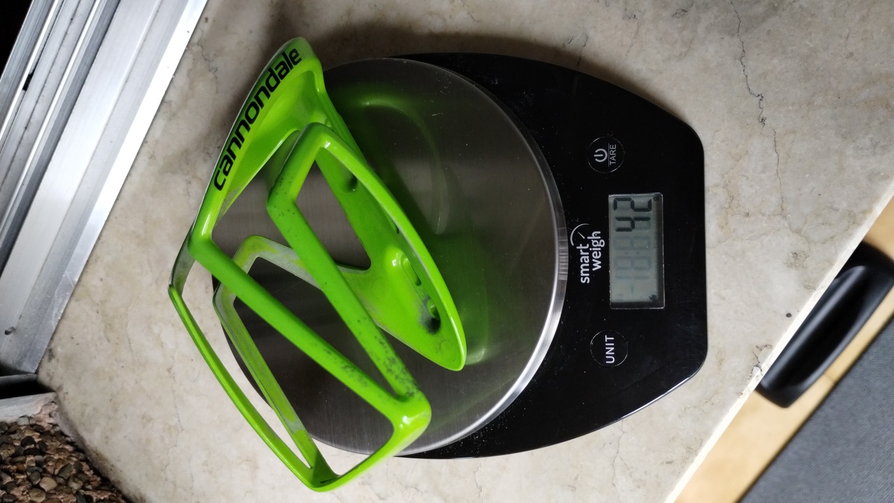 My old cannondale bottle cage, on a scale to measure its weight. The scale shows 42 grams