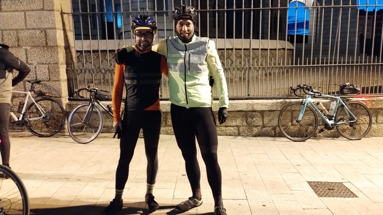 Me and dani at the start, there are several road bikes leaning on a wall behind us, near the walls of the Palacio de Gaudi palace