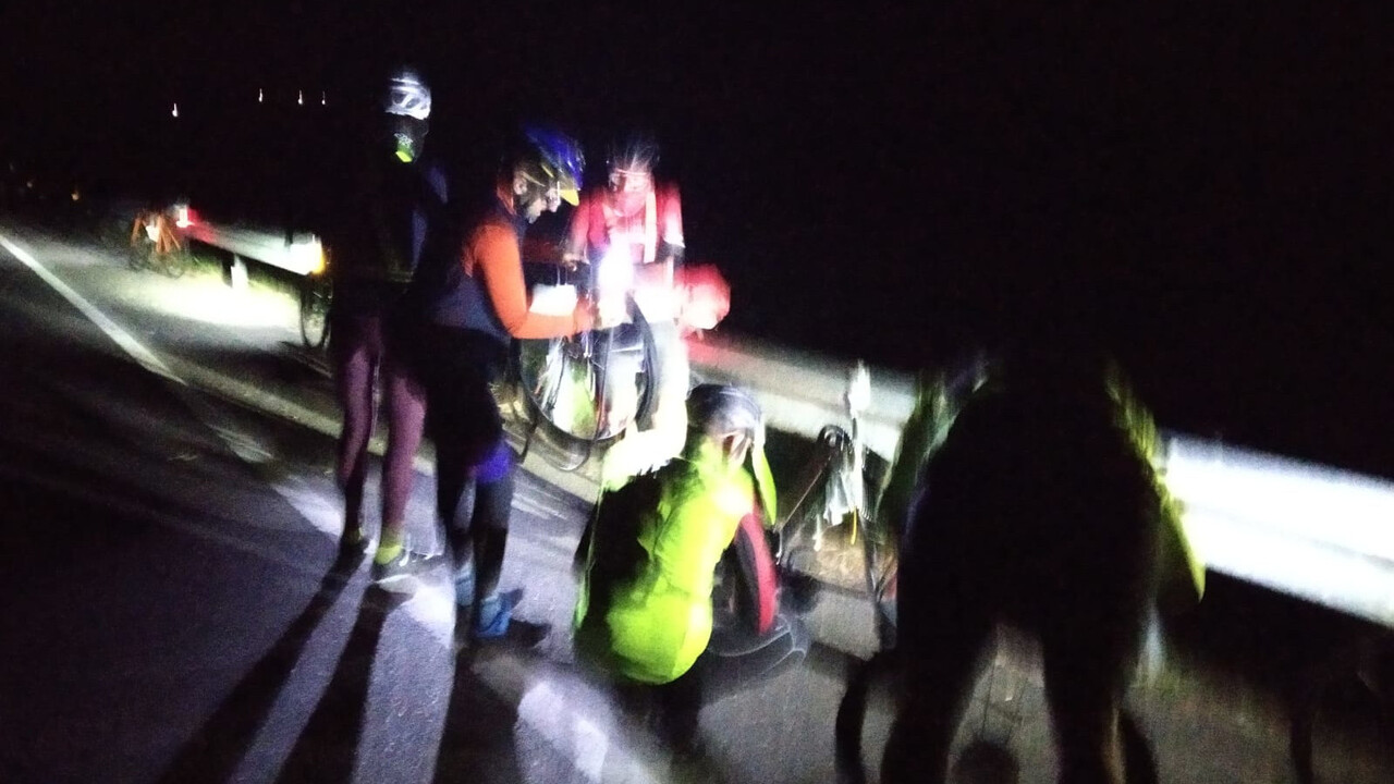 Blurry close up of our group at work, fixing my double pinch flat, in the middle of the night