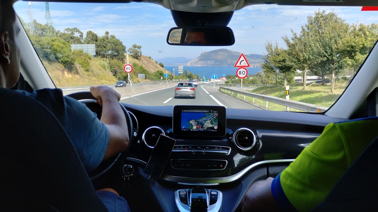 Picture taken from the middle of the back seat of the Van. Ferreiro is driving and Manolo is the copilot. There is a nice view of a bay in the cantabric sea coast in front of us.