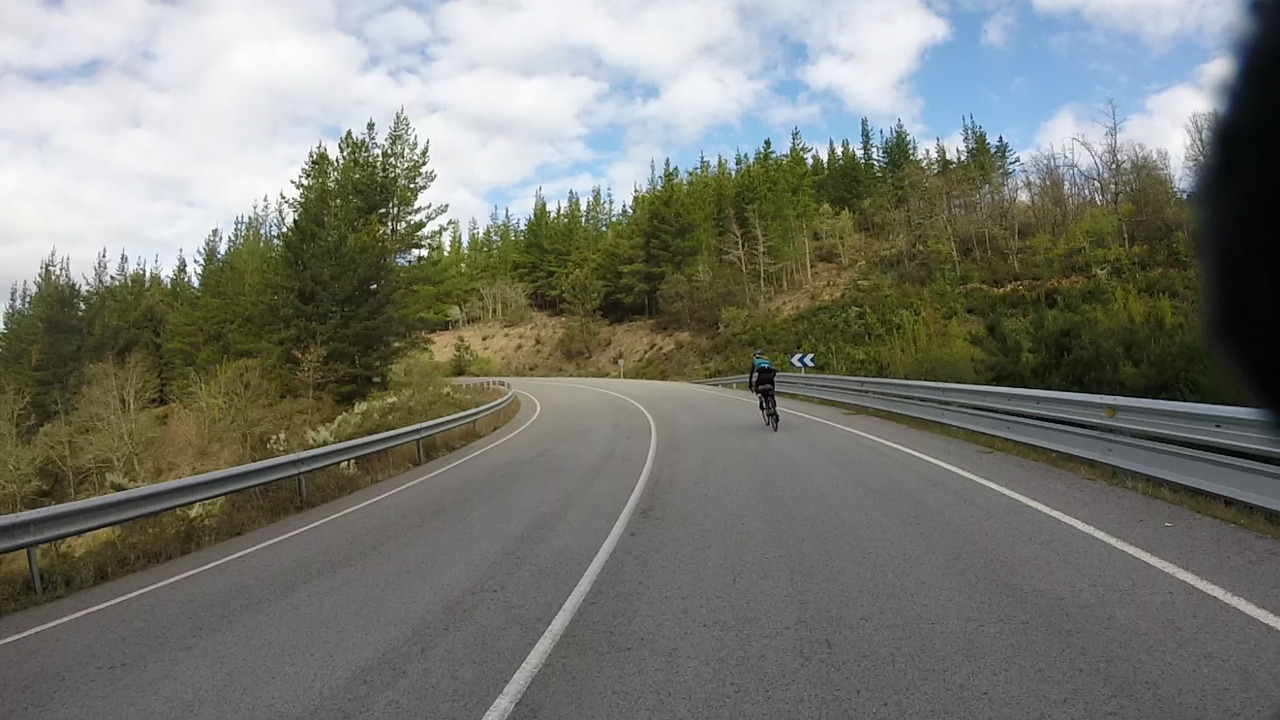The road up the short climb after Toreno, Estefanía is riding strong, there are trees on both sides of the road.