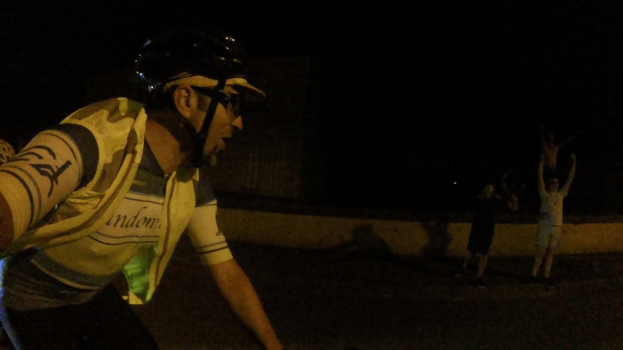 A bunch of kids, by the road, waiting for riders to pass by and making 'a wave' when we were passing by