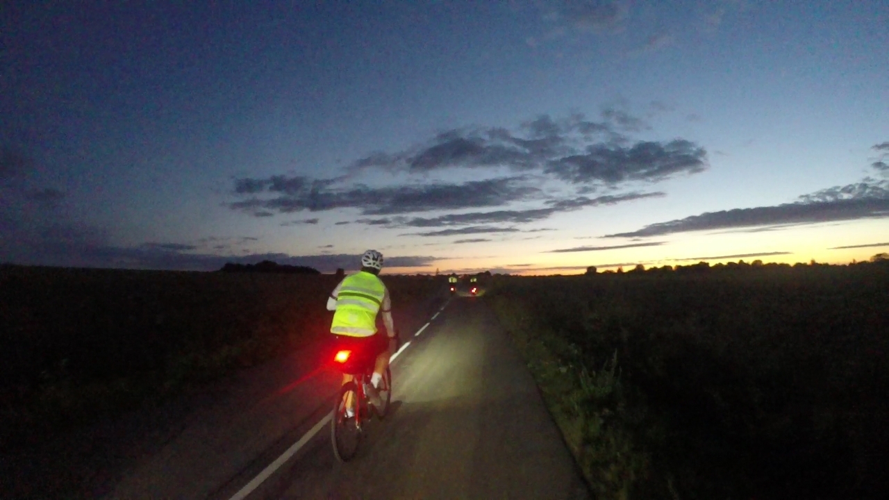 A randonneur, chasing a couple of tail lights towards the sunset
