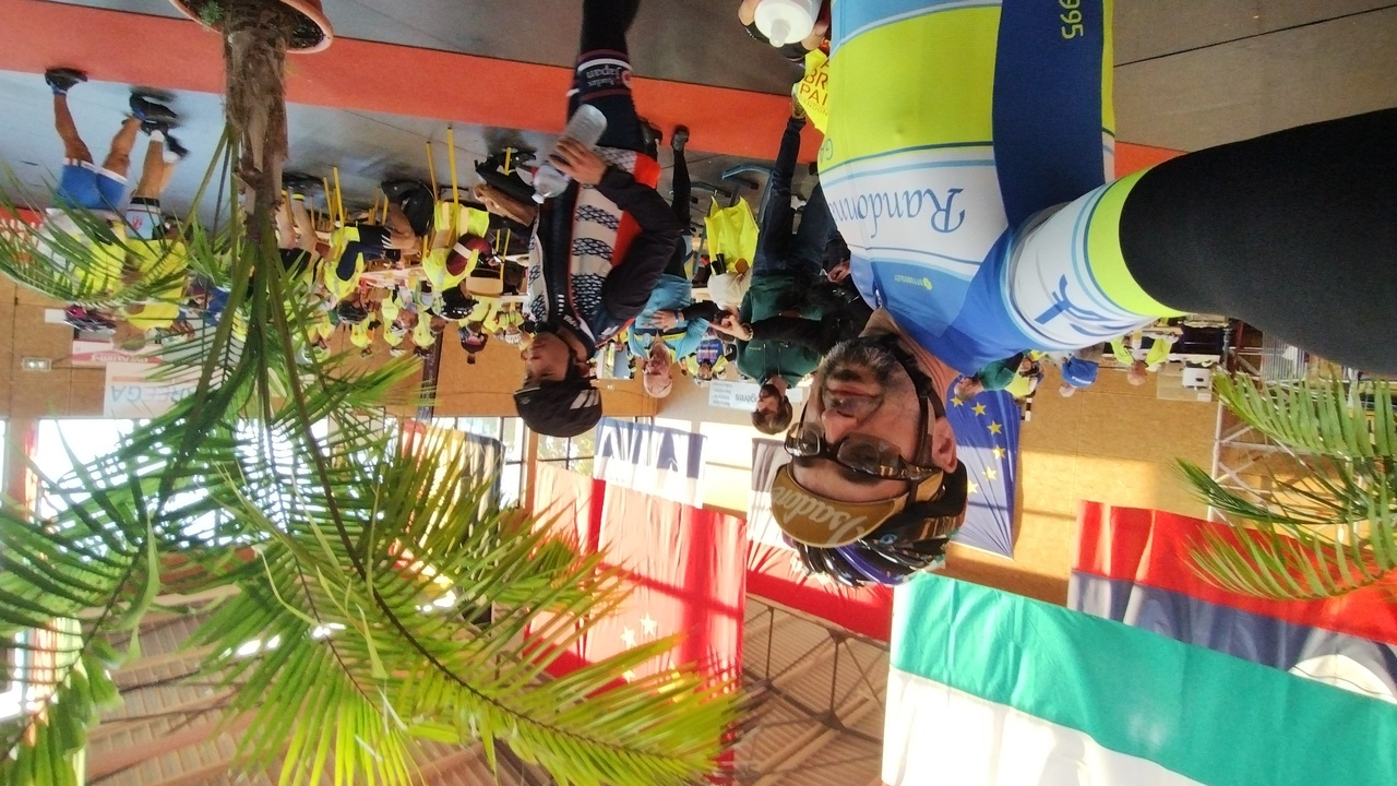 Selfie in the control in Fougerès, the huge country flags behind me, as well as the cafeteria tables, that were full of randonneurs having breakfast
