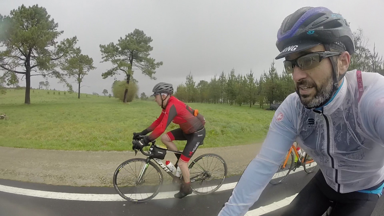 Jose pedaling on his second-hand Giant TCR, with more trees on the back and me on the right side, yes, still smiling