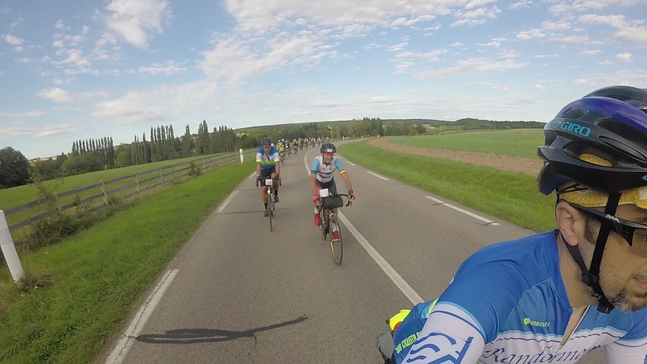 Selfie, in front of a long line of randonneurs coming up a short not-so-steep hill
