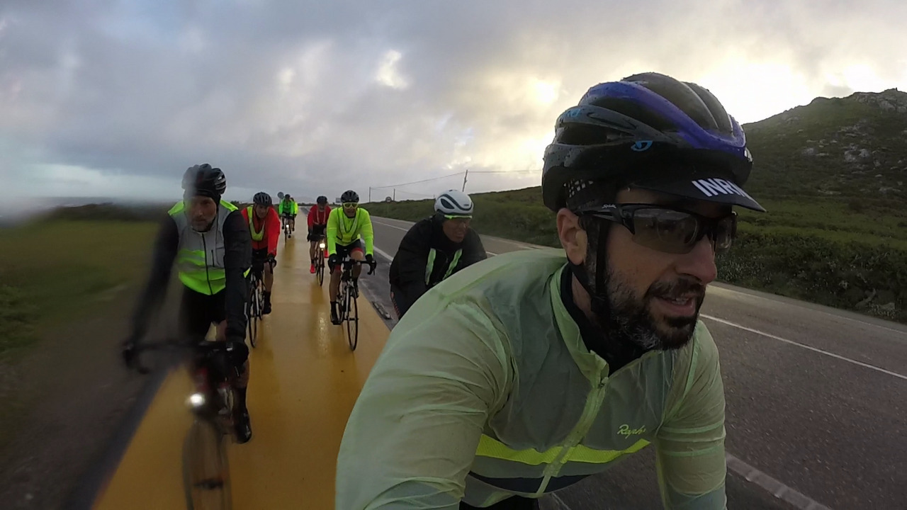Leading a group of several randonneurs, riding in pairs on the bike lane by the coast, under the rain