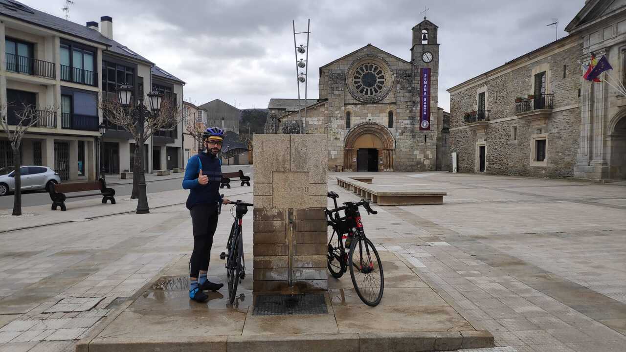 Me and our bikes, by the fountain in Meira's old square, near the monastery and the church