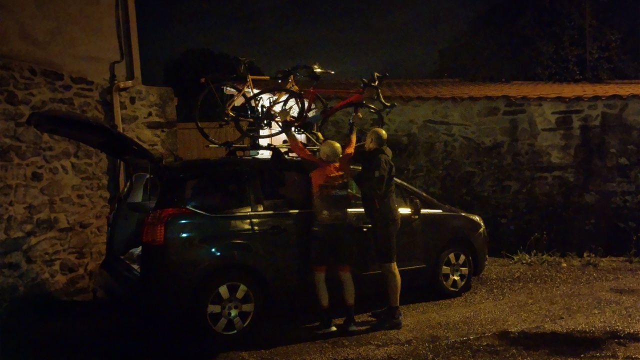 Dani and Josep, putting some bikes on the roof of Dani's car, in the middle of the night