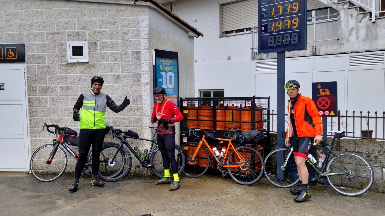 Dani, Edgar and Oscar, with their bikes, at the gas station in portomouro