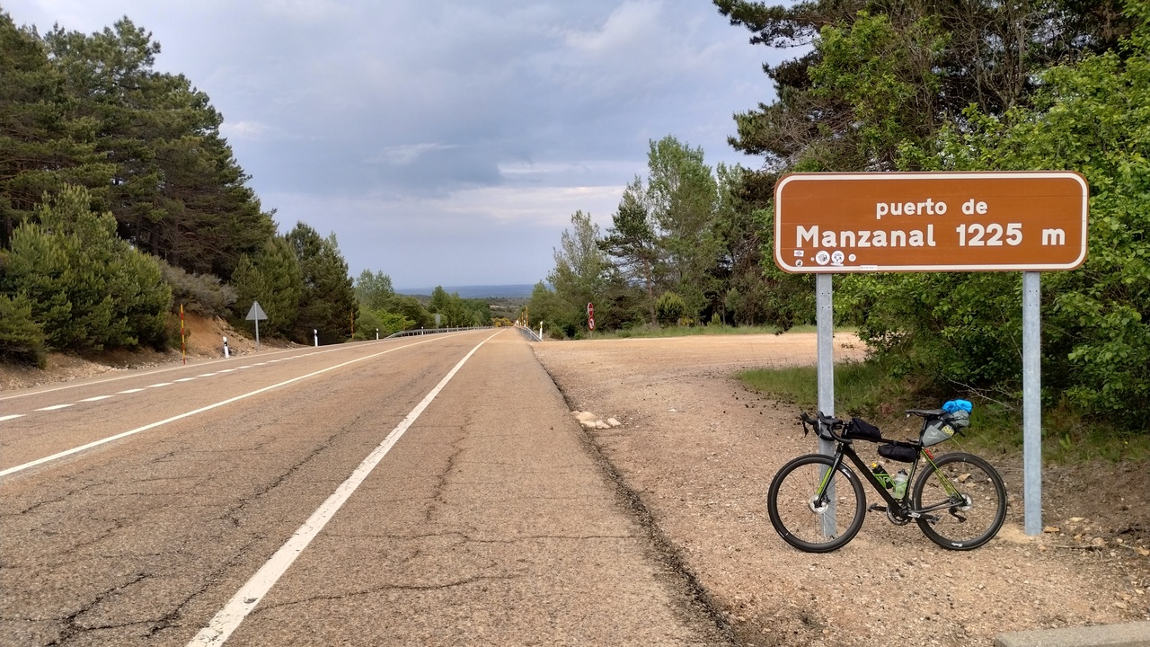 The synapse, leaning on the sign that said 'Puerto de Manzanal - 1225m' by the side of the road that would take us to Astorga and San Justo de la Vega