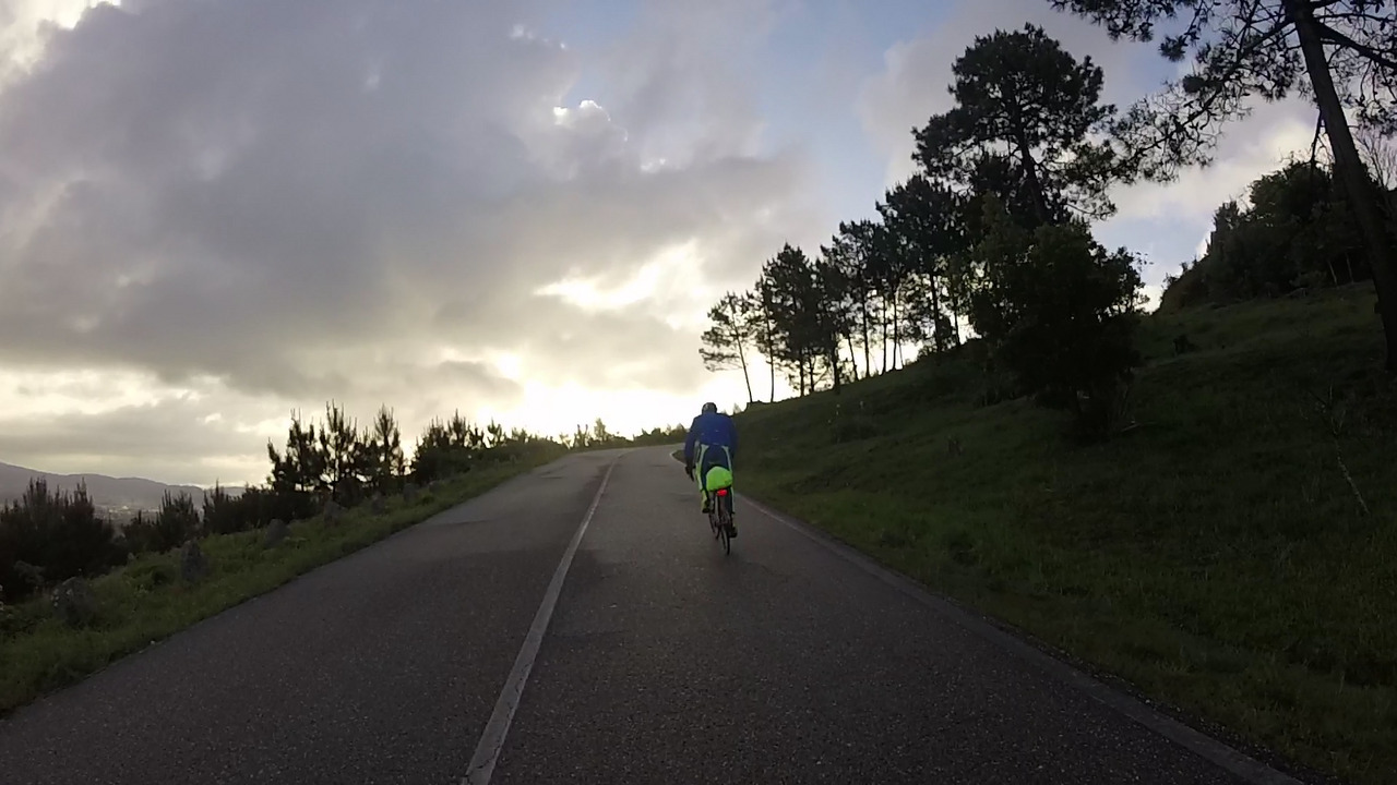 Alfonso riding in front of me, going up to Santa Trega under a sky completely covered with dark clouds