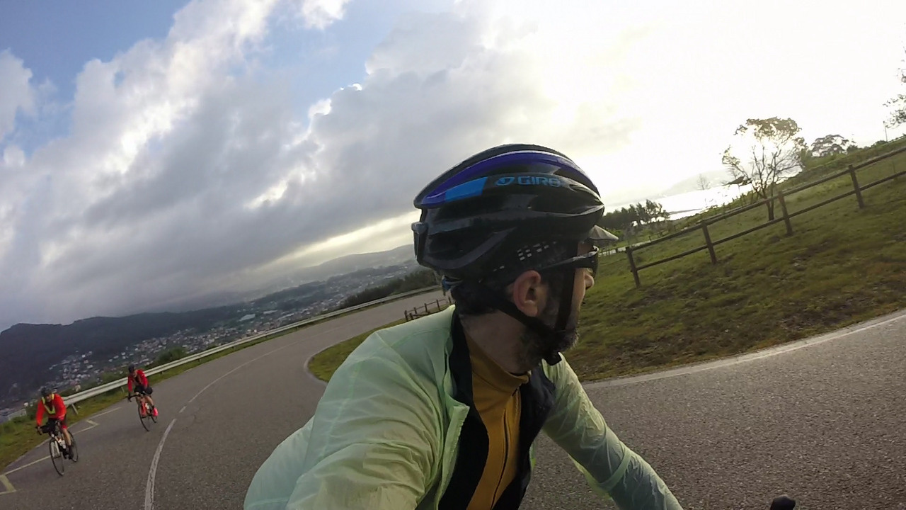 Me, chased by Jose and Edgar up to Santa Trega, the photo is a bit tilted to the left, the sky filled with grey and white clouds, the right side of the picture all white because of the sun shining from behind the clouds