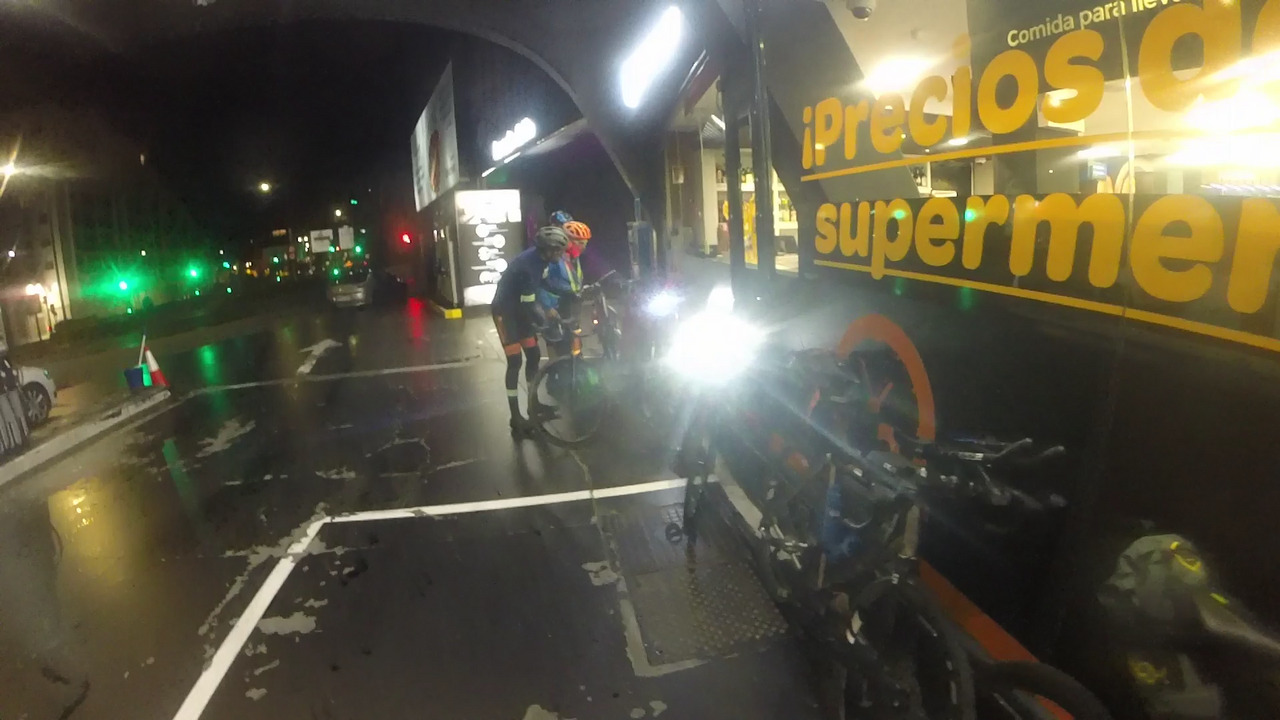 Sergio, Roberto and Saul, picking up some things from their bikes before entering the supermarket at the gas station in santiago