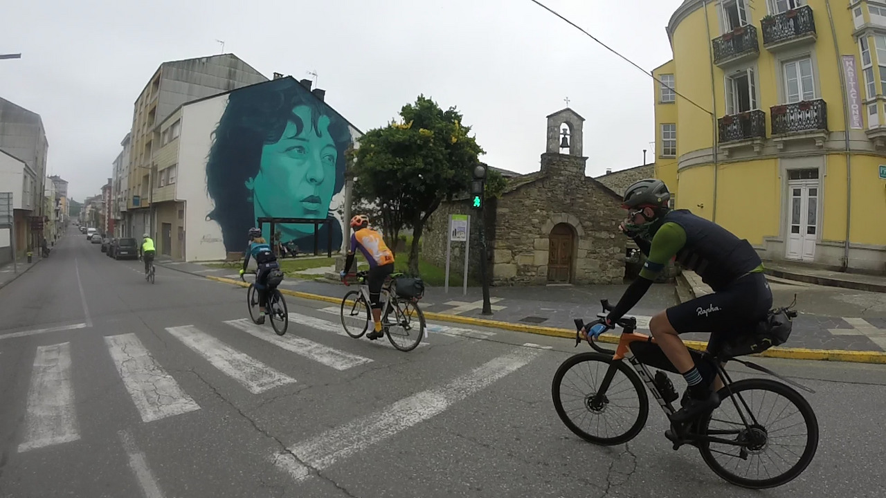 The group, passing by a big graffiti in one of the streets in Sarria