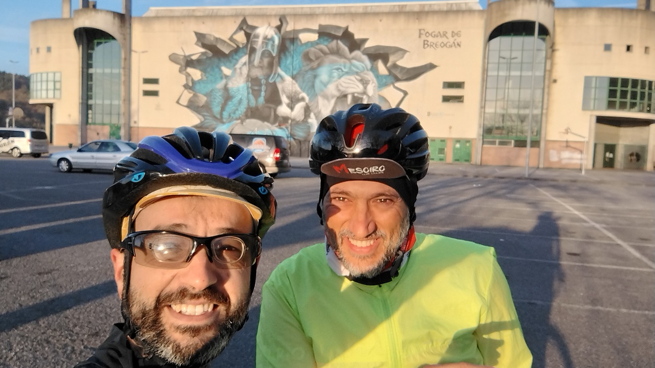 Dani and me at the start, in the parking lot by the stadium where the local basketball team plays its home matches, there is a big graffiti on the wall of the stadium, with a roman warrior and a lion, the symbols of the basketball team Breogan, a legend says 'Fogar de Breogan'