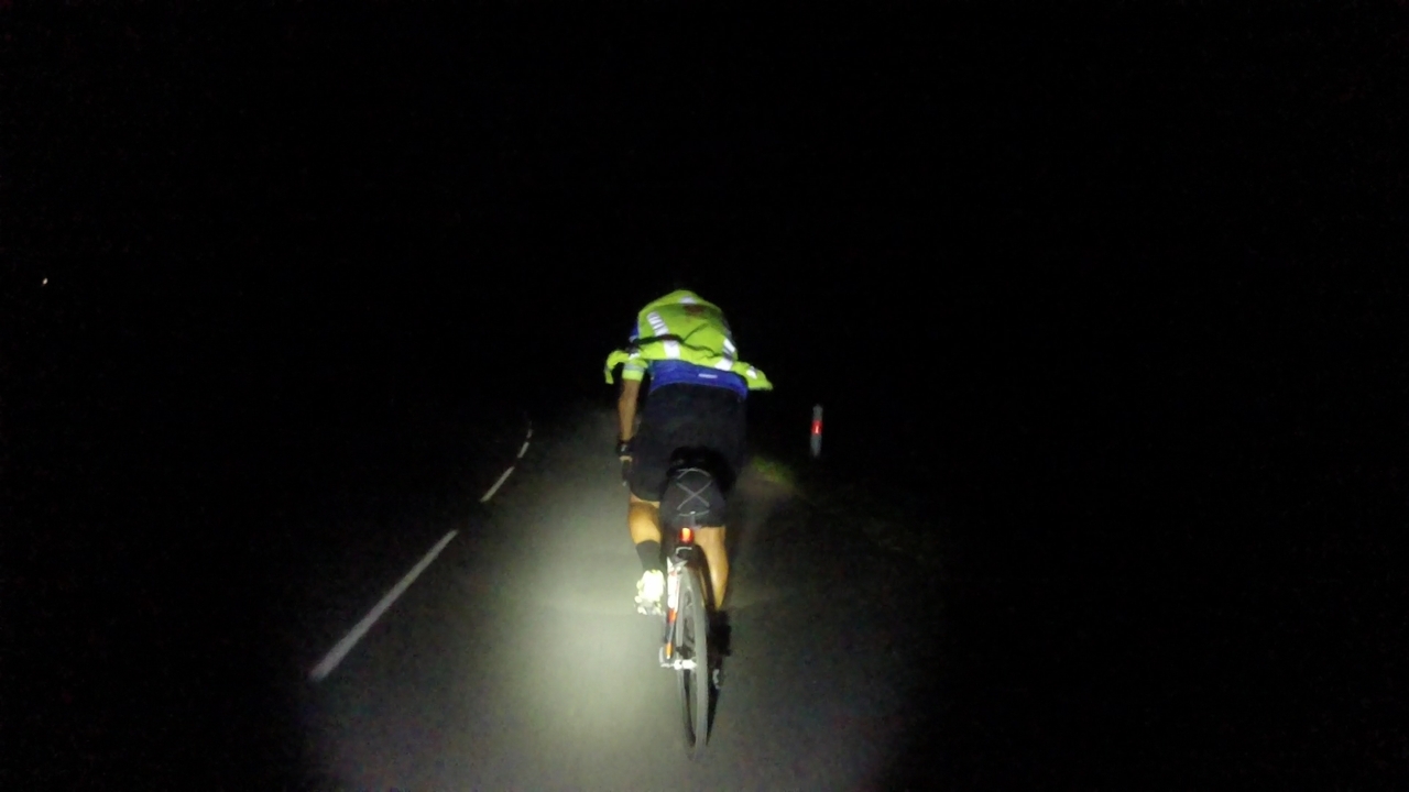 Dani, riding in front of me and lighted up by my head light, complete darkness surrounding him