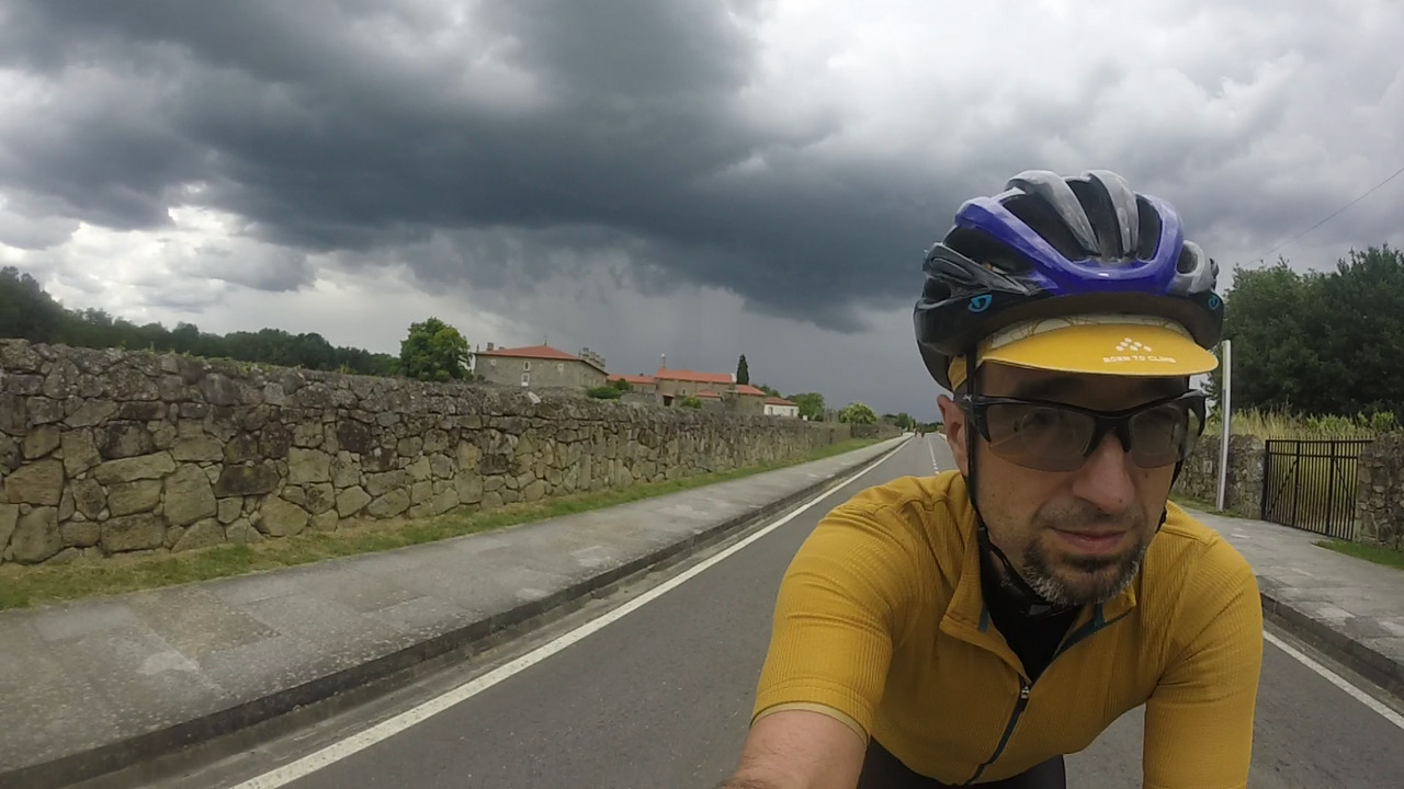 Me, passing by the old wall that surrounds the monastery, dark threatening clouds cover the sky behind me