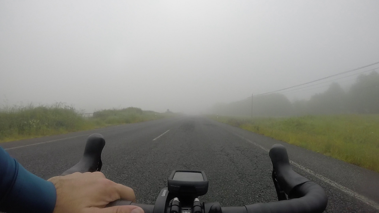 My handlebar, with my left hand on it. All around and in front of it, thick fog covering everything