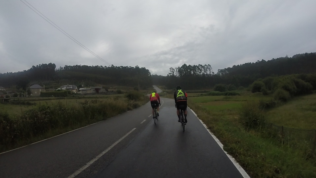 Oscar and Dani on their way to Faro de Punta Roncadoira, riding on a small secondary road, all wet because of the constant rain