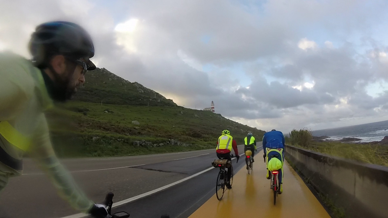Riding behind a group of several randonneurs along the Atlantic Coast, approaching a lighthouse