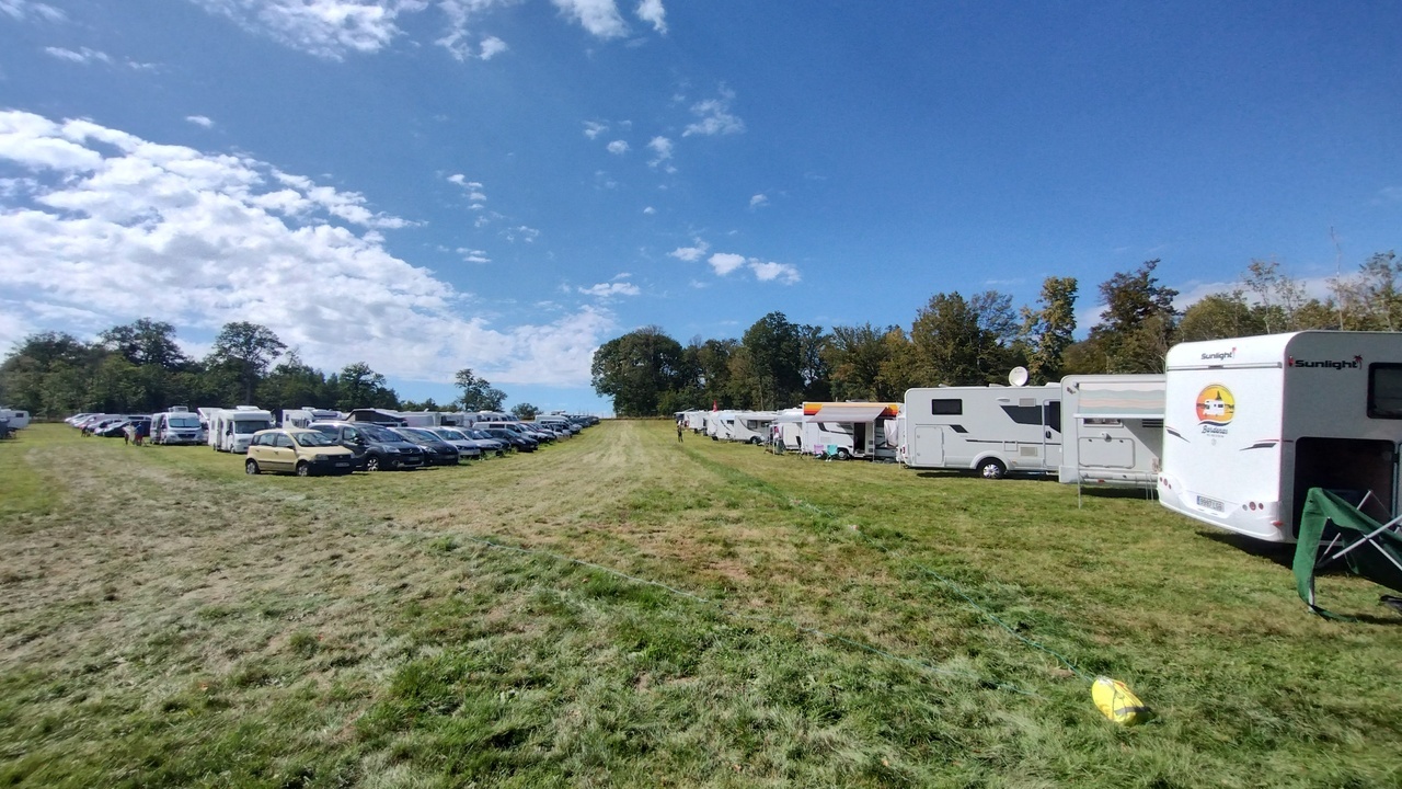 A few rows of vans, campers and small motorhomes, parked in the parking area in Rambouillet