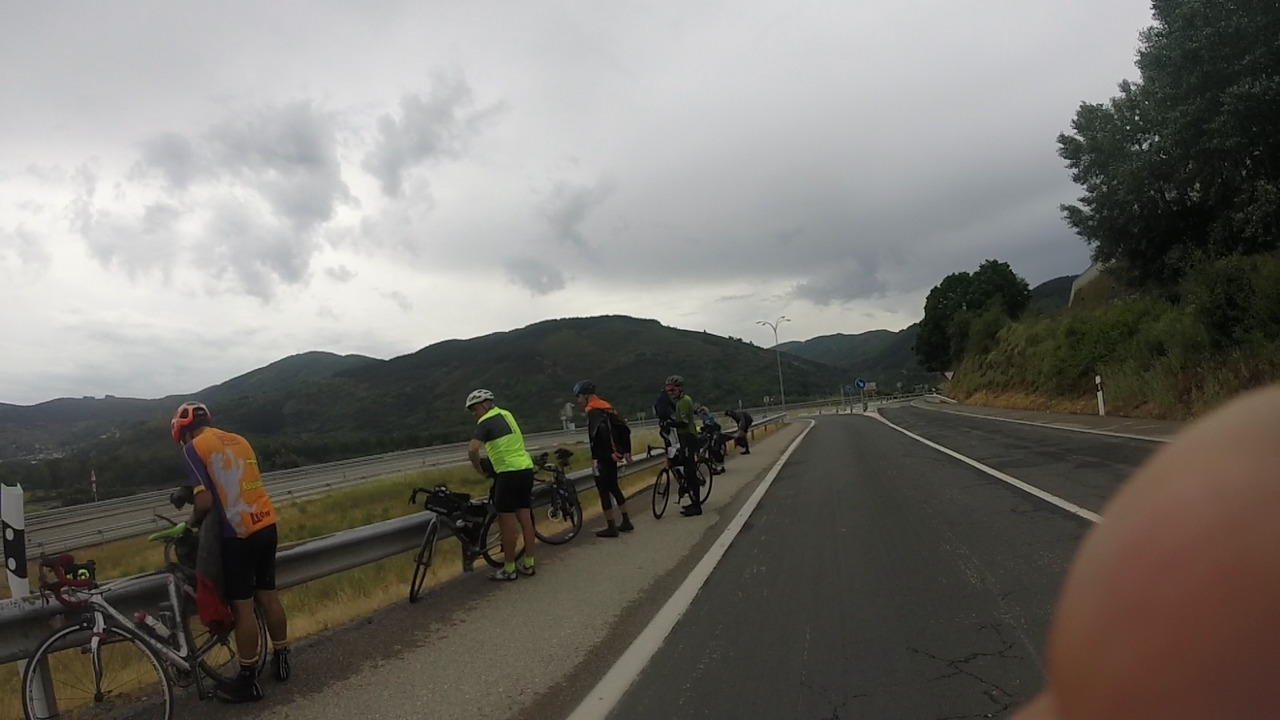 Everybody lined up by a road barrier on our way out of Villafranca, rearranging things in their bags.
